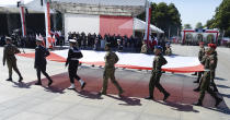 Soldiers carry a large Polish flag as Poland marks the centennial of the Battle of Warsaw, a Polish military victory in 2020 that stopped the Russian Bolshevik march toward the west, in Warsaw, Poland, Saturday, Aug. 15, 2020. U.S. Secretary of State Mike Pompeo attended as he wrapped up a visit to central Europe. (AP Photo/Czarek Sokolowski)