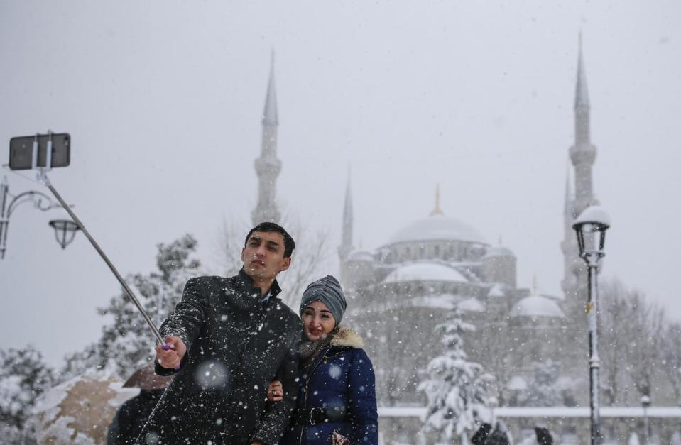 In this photo taken on Monday, Jan. 9, 2017, a couple takes a selfie at Sultanahmet district, one of Istanbul's main tourist attractions. TThese days, with a string of terror attacks targeting Istanbul still fresh in his memory, some residents say they are adapting their daily routines because of fears they could become the latest victims of violent extremism. (AP Photo/ Emrah Gurel)