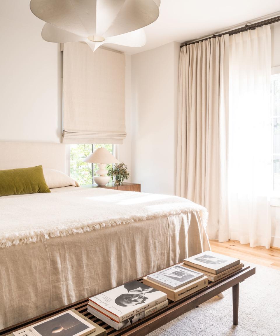 White bedroom, green cushion, wooden stool