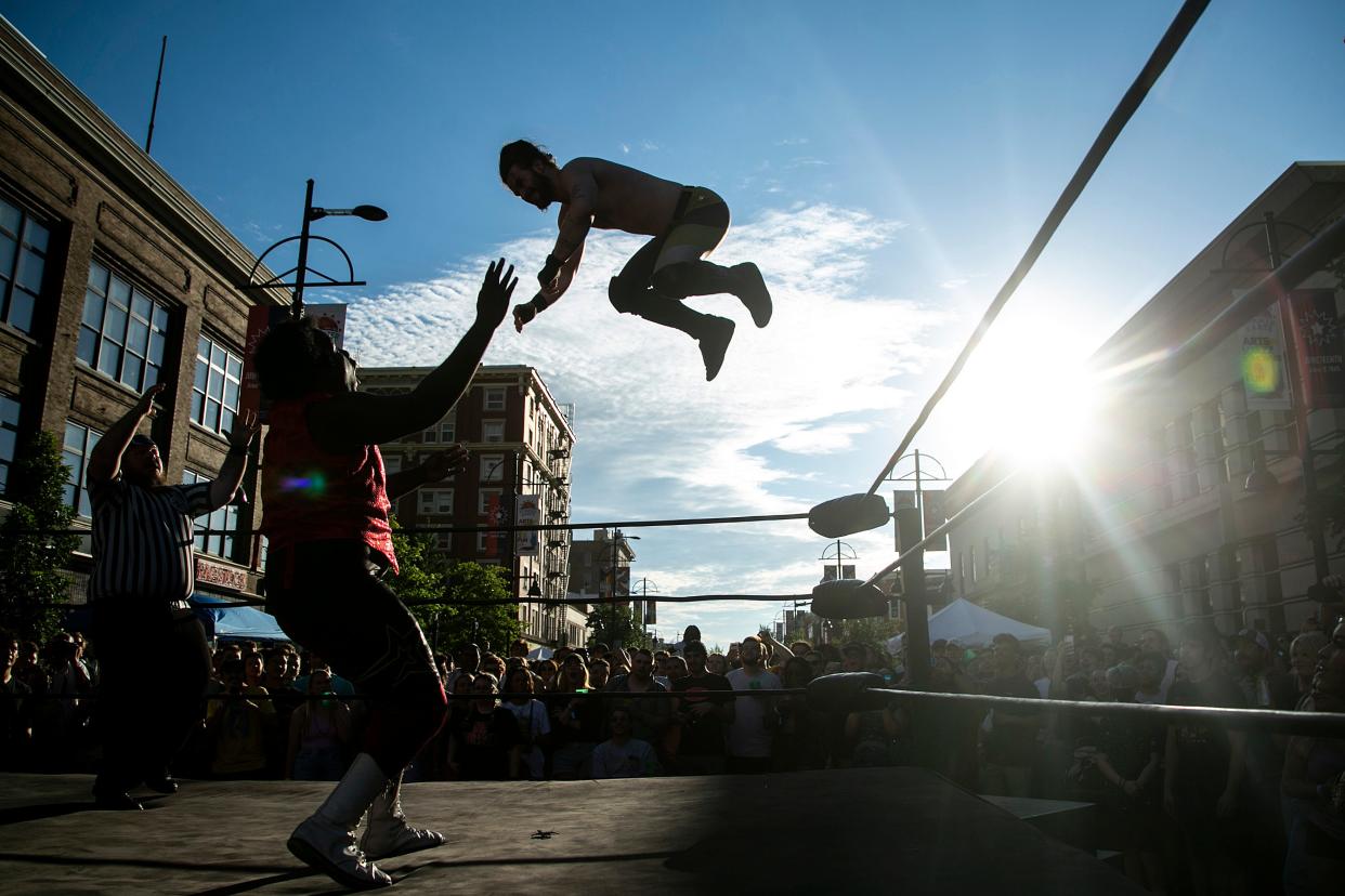 Shain Boucher leaps from the top rope onto James Thomas during a SCWPro wrestling show at the fifth Downtown Block Party, Saturday, June 25, 2022, in Iowa City, Iowa.