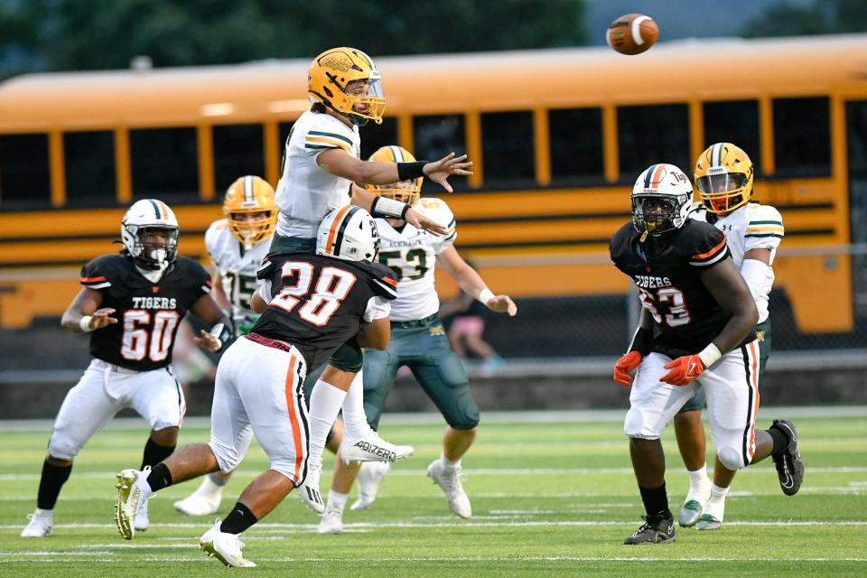 Blackhawk quarterback Stephen Knallay passes the ball while being tackled by Beaver Falls' Brixx Rawl during Friday's Week 0 game at Reeves Field at Geneva College.