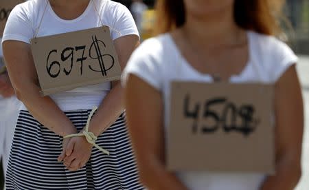 Activists wear price tags as they take part in a flash mob in Prague, Czech Republic, organised by Amnesty International to draw attention to inhuman treatment of migrants in Libya, June 20, 2018. REUTERS/David W Cerny