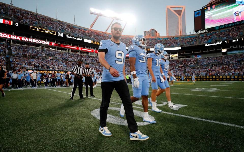 Eric Church, wearing Tez Walker’s jersey, walks out with the captains for the coin toss before UNC’s game against South Carolina in the Duke’s Mayo Classic at Bank of America Stadium in Charlotte, N.C., Saturday, Sept. 2, 2023. Ethan Hyman/ehyman@newsobserver.com