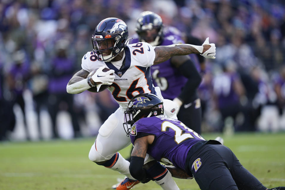 Denver Broncos running back Mike Boone (26) comes under pressure from Baltimore Ravens safety Geno Stone (26) as he carries the ball in the second half of an NFL football game, Sunday, Dec. 4, 2022, in Baltimore. (AP Photo/Patrick Semansky)