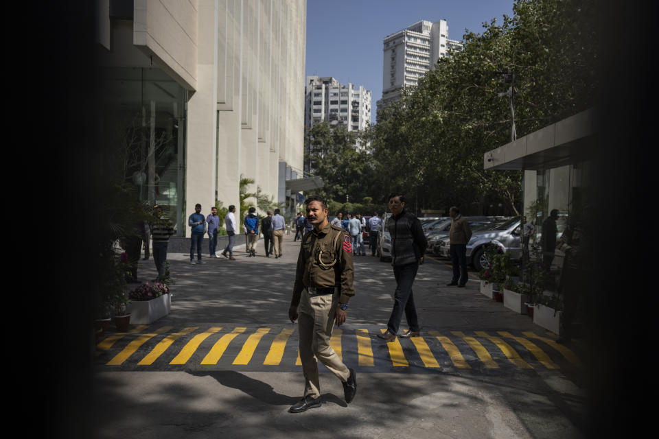 A police officer is seen at the gate of a building housing BBC office in New Delhi, India, Tuesday, Feb. 14, 2023. Officials from India's Income Tax department began conducting searches Tuesday at the BBC's offices in the capital, New Delhi, three of the broadcaster's staff members told the Associated Press. (AP Photo/Altaf Qadri)