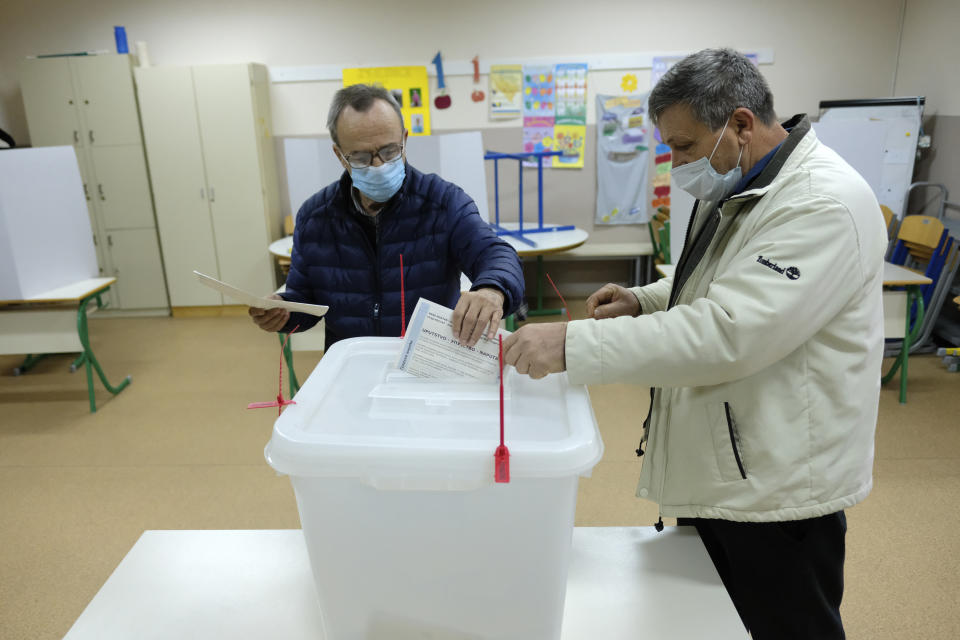 A man casts his ballot for the local elections at a polling station in Mostar, Bosnia, Sunday, Dec. 20, 2020. Divided between Muslim Bosniaks and Catholic Croats, who fought fiercely for control over the city during the 1990s conflict, Mostar has not held a local poll since 2008, when Bosnia's constitutional court declared its election rules to be discriminatory and ordered that they be changed. (AP Photo/Kemal Softic)