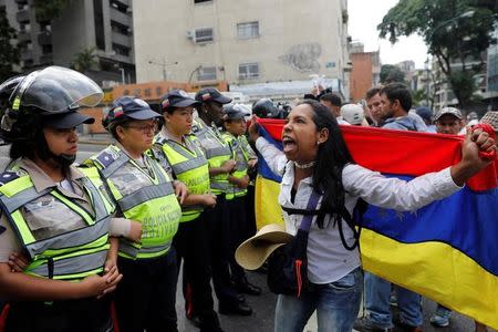 A demonstrator shouts slogans in front of police officers during a women's march to protest against President Nicolas Maduro's government in Caracas, Venezuela May 6, 2017. REUTERS/Carlos Garcia Rawlins