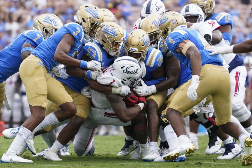 South Alabama running back La'Damian Webb (3) is tackled by UCLA defenders during the first half of an NCAA college football game in Pasadena, Calif., Saturday, Sept. 17, 2022. (AP Photo/Ashley Landis)