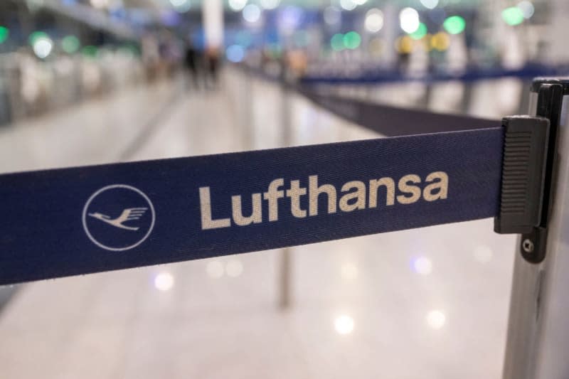 The Lufthansa logo can be seen on a barrier tape at check-in at the airport. The cabin crew union Ufo has called on around 19,000 airline employees to go on strike. All Lufthansa departures from Munich will be on strike from 4.00 am to 11.00 pm. Peter Kneffel/dpa