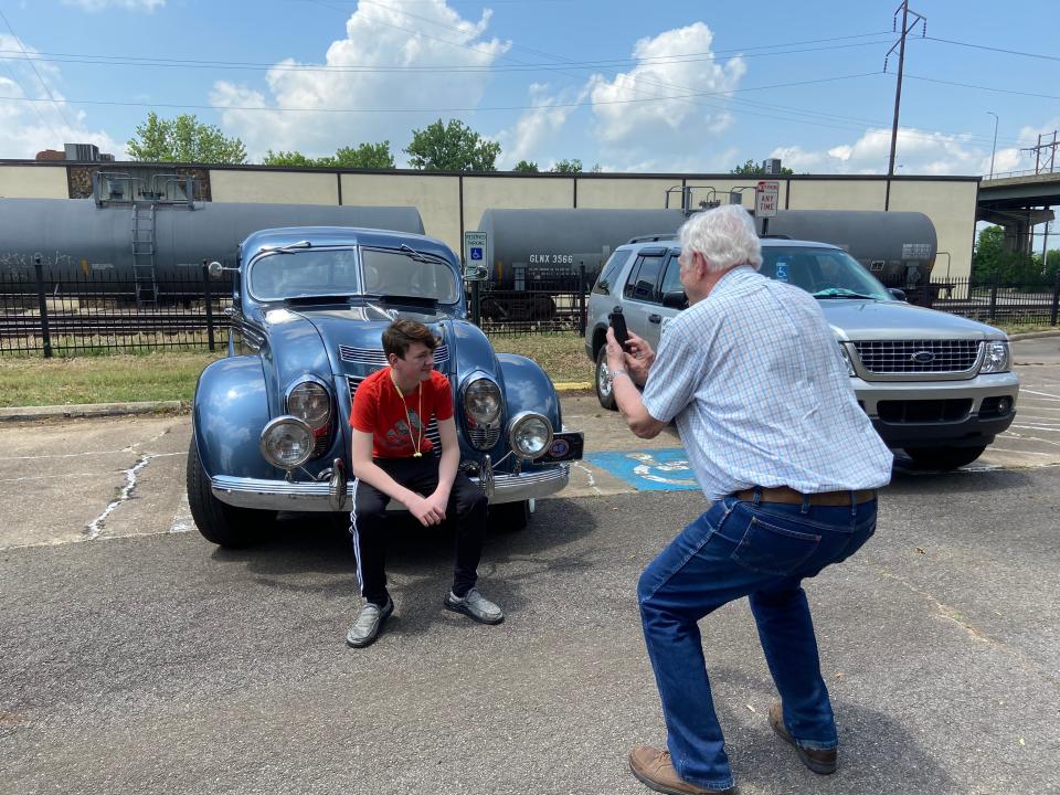 A grandfather takes a picture of his grandson with an antique car donated for the event by Fort Smith Antique Auto Club.