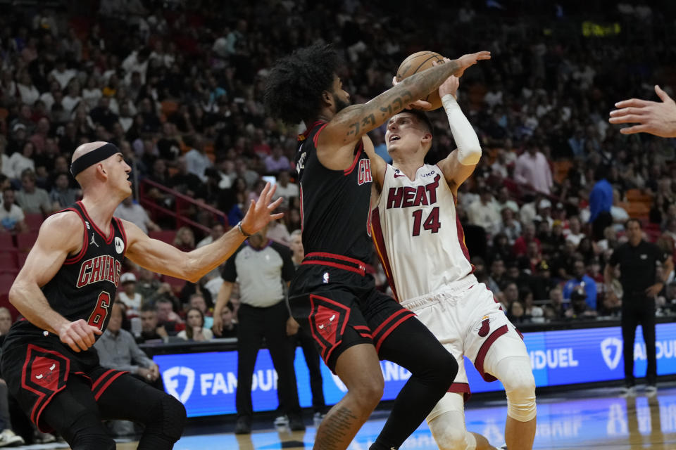 Miami Heat guard Tyler Herro (14) is fouled by Chicago Bulls guard Coby White during the first half of an NBA basketball play-in tournament game, Friday, April 14, 2023, in Miami. (AP Photo/Rebecca Blackwell)