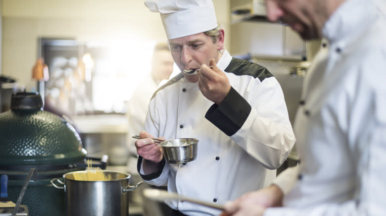 chef tasting pot of food