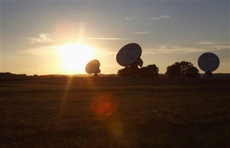 File photo of protected satellite earth station dishes standing in a field during sunset in the southern Bavarian village of Raisting, 40 km (25 miles) south of Munich July 22, 2013. REUTERS/Michaela Rehle/Fiels