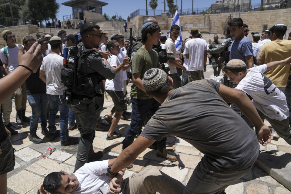 Israeli police officers separate Israelis and Palestinians in front of the Damascus Gate of Jerusalem's Old City shortly before a march through the area by Jewish nationalists in Jerusalem Day, an Israeli holiday celebrating the capture of east Jerusalem in the 1967 Mideast war, Wednesday, June 5, 2024. (AP Photo/Mahmoud Illean)