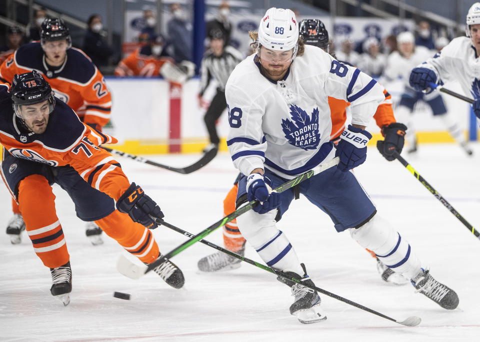 Edmonton Oilers' Evan Bouchard (75) chases Toronto Maple Leafs' William Nylander (88) during first-period NHL hockey game action in Edmonton, Alberta, Monday, March 1, 2021. (Jason Franson/The Canadian Press via AP)