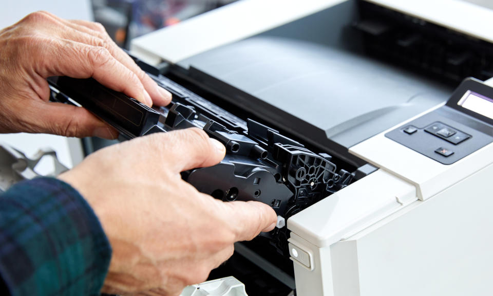 A person removing a printer tray