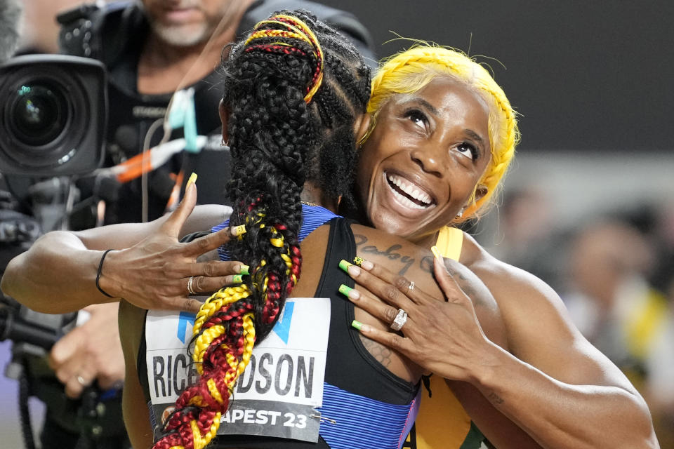 Bronze medalist Shelly-Ann Fraser-Pryce, of Jamaica, right, and gold medalist Sha'Carri Richardson, of the United States, hug each other after the Women's 100-meter final during the World Athletics Championships in Budapest, Hungary, Monday, Aug. 21, 2023. (AP Photo/Matthias Schrader)