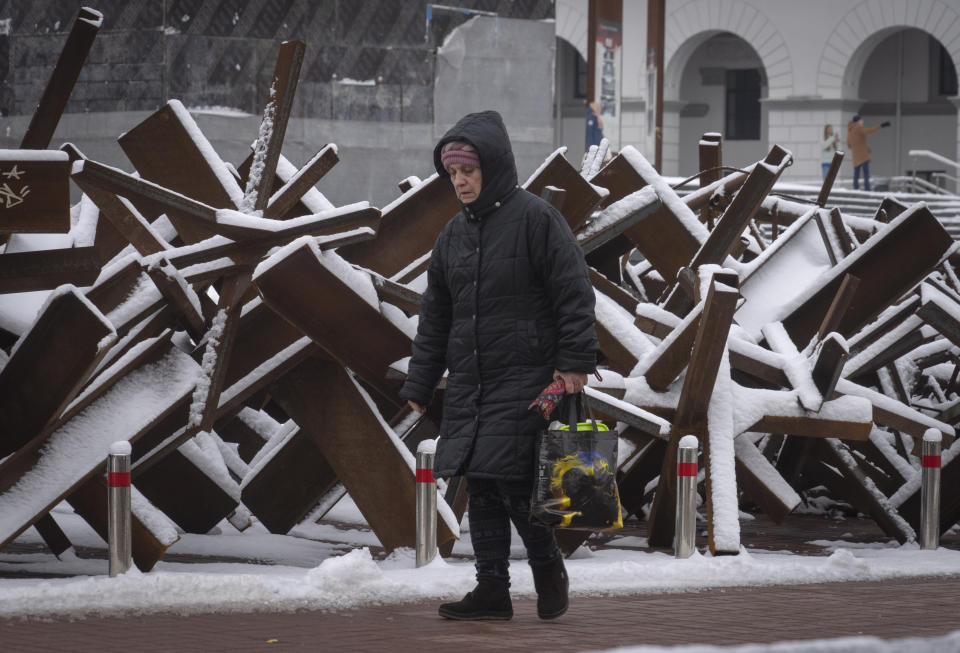 A woman passes by anti-tank hedgehogs in central Kyiv, Ukraine, Monday, Dec. 12, 2022. Ukraine has been fighting with the Russian invaders since Feb. 24 for over nine months. (AP Photo/Efrem Lukatsky)