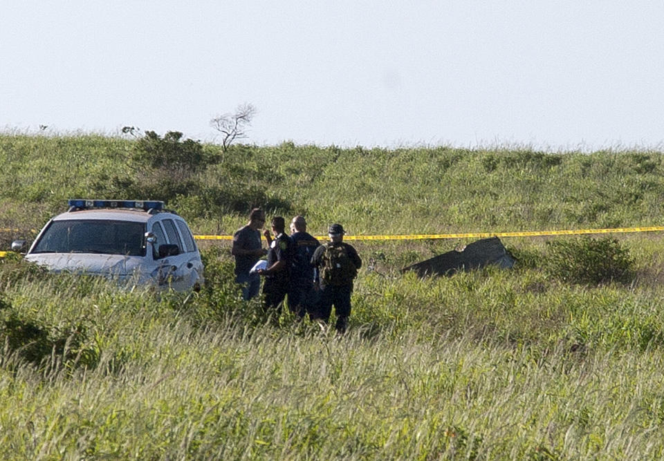 This Thursday, Feb. 27, 2014 photo released by Russell deJetley shows officials at the site of a plane crash in Lanai City, Hawaii. A small plane crashed and burst into flames shortly after takeoff from Hawaii's Lanai island, killing three people and leaving three others injured, authorities said Thursday. The crash occurred around 9:30 p.m. Wednesday about a mile from Lanai Airport in the Miki Basin area, Maui County spokesman Rod Antone told The Associated Press. (AP Photo/Russell deJetley)