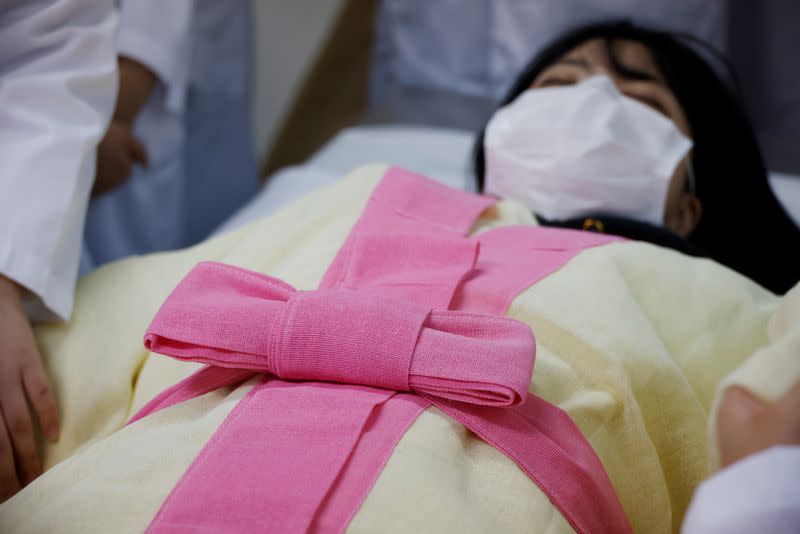 Park Se-jung who majors the funeral directing at Eulji University, is laid for practice of how to shroud the deceased during a class, in Seongnam