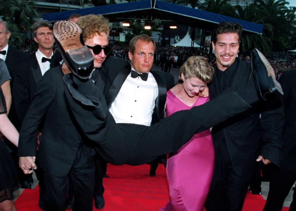 Woody Harrelson is held by director Michael Cimino (left) and actors Alexandra Tydings and Jon Seda as they arrive for the screening of their film ‘Sunchaser’ at the 49th Cannes on 18 May 1996 (Reuters)