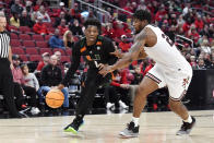 Miami forward Anthony Walker (1) drives around Louisville forward Sydney Curry (21) during the first half of an NCAA college basketball game in Louisville, Ky., Sunday, Dec. 4, 2022. (AP Photo/Timothy D. Easley)