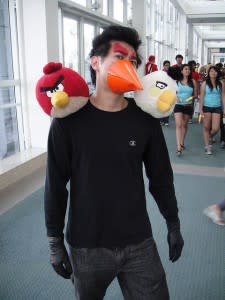 Man with plastic beak and two angry birds on his shoulders