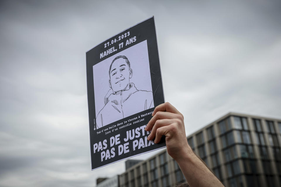 A protestor holds up a banner that reads: "Nahel, 17 years old, No Justice. No Peace", during a silent march called by the mother of 17-year-old Nahel Merzouk who was killed by police to mark one year since his death, in Nanterre, west of Paris, Saturday, June 29, 2024. The murder of 17-year-old Nahel by an on-duty police officer in June 2023 sparked riots across France. (AP Photo/Aurelien Morissard)