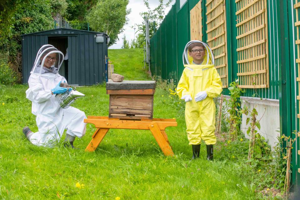 Iulia, 10, and seven-year-old Eric Dumitrescu, pictured at the new hives on the hospital campus. (Brian Lougheed/PA)