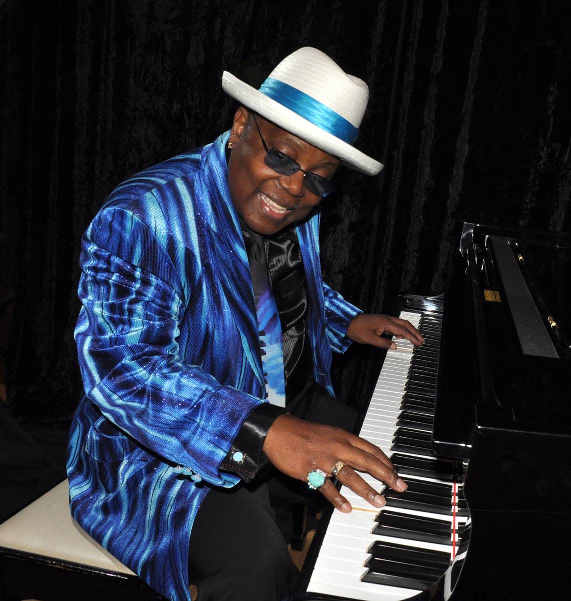 Kenny Wayne, aka the Blues Boss, plays the piano in an electric blue ensemble.