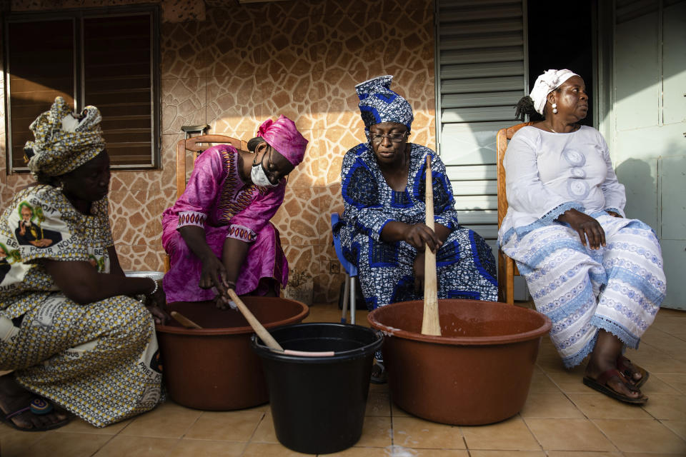 Women gather to make soap at Zenabou Coulibaly Zongo's house in Ouagadougou, Burkina Faso, Tuesday, Oct. 26, 2021. Zongo spends her own money making soap and buying hand sanitizer for mosques, markets and health centers. At the start of the pandemic, Zongo, now 63, was hospitalized with bronchial pneumonia. She paid out of pocket for two weeks' worth of oxygen treatments at a private clinic, where she watched others die from respiratory problems. (AP Photo/Sophie Garcia)