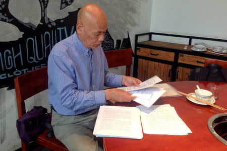 Xu Xiaoshun, the father of activism blogger Wu Gan, who was detained in what is known as the "709" crackdown, looks through documents about his son's case in a restaurant in Jiangsu Province, China June 12, 2017. REUTERS/Christian Shepherd