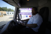 Learner truck driver Cadhene Lubin-Hewitt poses for a portrait in the cab of a truck at the National Driving Centre in Croydon, south London, Wednesday, Sept. 22, 2021. Lubin-Hewitt, 32, moved to the UK when he was 16 from Trinidad and Tobago and has been driving buses and coaches for about 10 years. Britain doesn't have enough truck drivers. The shortage is contributing to scarcity of everything from McDonald's milkshakes to supermarket produce. (AP Photo/Matt Dunham)