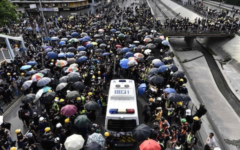 Crowds of Hong Kong protesters defied a police ban and began gathering in a town close to the Chinese border to rally against suspected triad gangs who beat up pro-democracy demonstrators there last weekend. - Credit: ANTHONY WALLACE/AFP/Getty Images