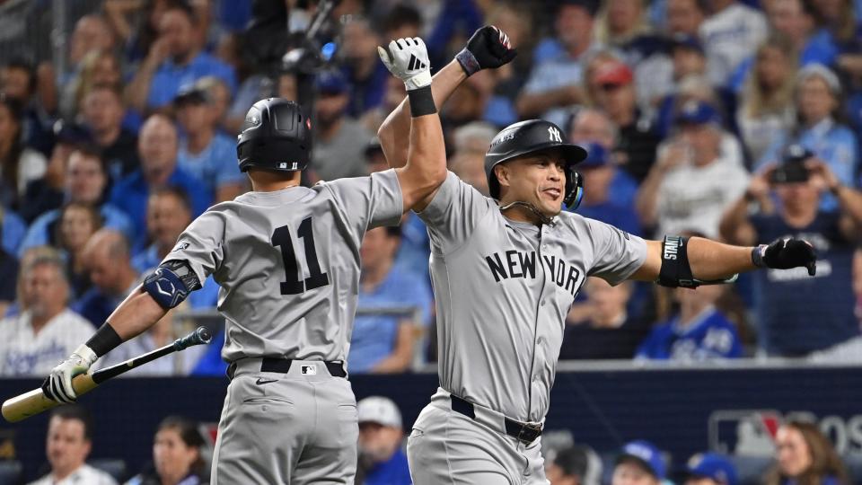 October 9, 2024; Kansas City, Missouri, USA; New York Yankees designated hitter Giancarlo Stanton (27) celebrates with Jazz Chisholm Jr. (13) at third base for the New York Yankees after hitting an eighth-inning home run against the Kansas City Royals during Game 3 of the NLDS of the 2024 MLB Playoffs at Kauffman Stadium. Mandatory Credit: Peter Aiken-Imagn Images