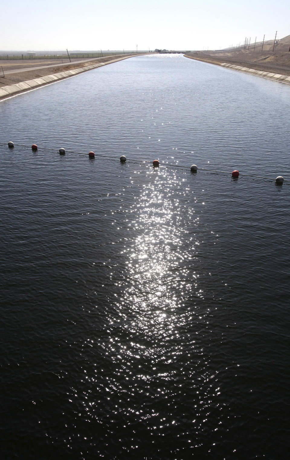 File - In this Oct. 8, 2009 file photo, sunlight is seen reflecting on water flowing south in the California Aqueduct near Patterson, Calif. The California Aqueduct has been ferrying water from the state’s verdant north to the south’s arid croplands and cities since Gov. Jerry Brown’s father was in office half a century ago. But now, amid one of the worst droughts on record, a group of farmers want to route some of that water back uphill. (AP Photo/Rich Pedroncelli, file)