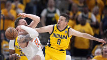 Indiana Pacers guard T.J. McConnell (9) fights for a loose ball with New York Knicks center Isaiah Hartenstein, left, during the second half of Game 6 in an NBA basketball second-round playoff series, Friday, May 17, 2024, in Indianapolis. (AP Photo/Michael Conroy)
