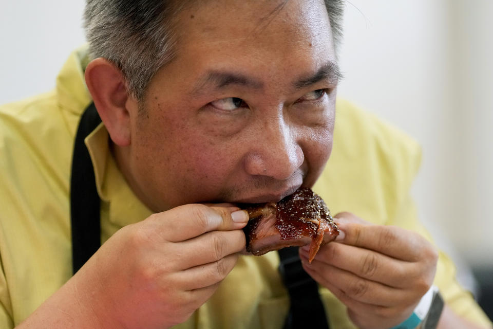 Barbecue judge Wayne Chang eats a rib at the World Championship Barbecue Cooking Contest, Saturday, May 18, 2024, in Memphis, Tenn. (AP Photo/George Walker IV)
