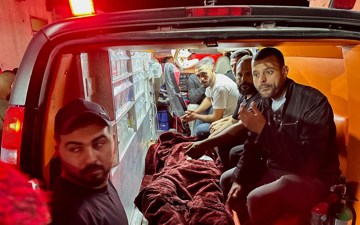 People transport the body of a Palestinian who was killed in an Israeli raid at Nur Shams camp