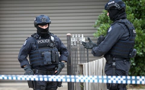 Police officers that form part of the Australian Joint Counter Terrorism Team stand outside a home they raided - Credit:  REUTERS