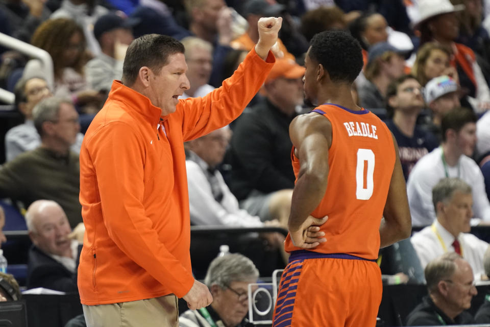 Clemson head coach Brad Brownell, left, talks with guard Kihei Clark (0) during the first half of an NCAA college basketball game against Virginia at the Atlantic Coast Conference Tournament in Greensboro, N.C., Friday, March 10, 2023. (AP Photo/Chuck Burton)