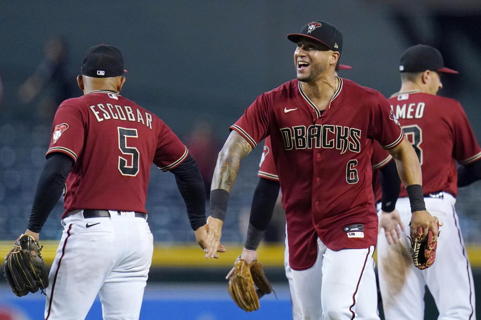 Arizona Diamondbacks' Eduardo Escobar (5), David Peralta (6) and Nick Ahmed, right, celebrate a win against the Pittsburgh Pirates in a baseball game Wednesday, July 21, 2021, in Phoenix. The Diamondbacks won 6-4. (AP Photo/Ross D. Franklin)