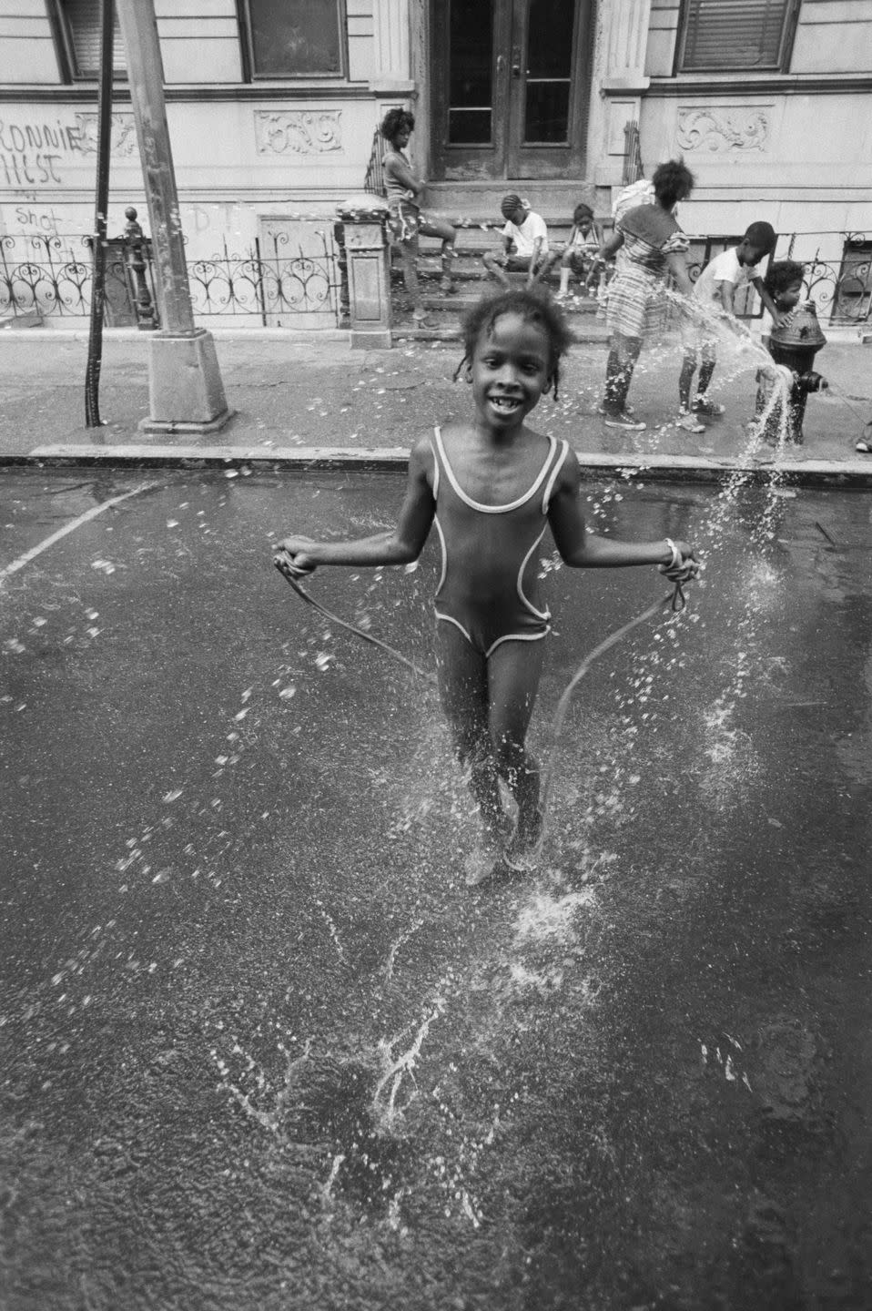 Little girl skips in spray of hydrant: 1973