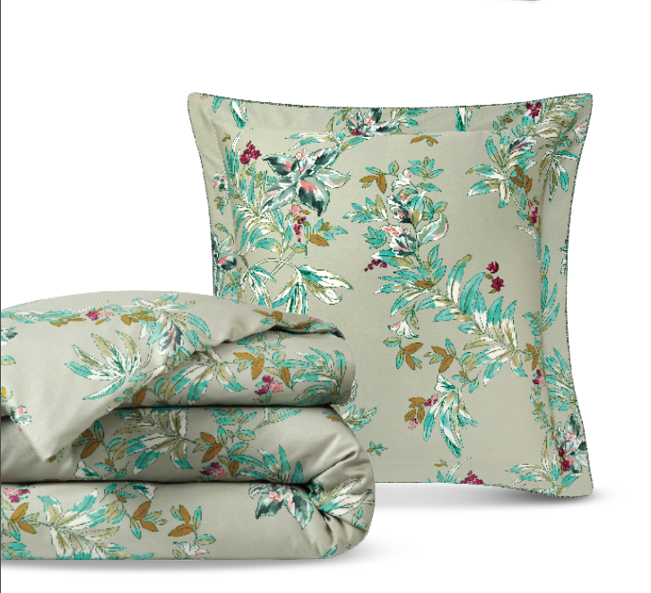a blanket and pillow in sage with green viney pattern with red bud berries