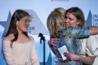 First lady Jill Biden, center, hugs designer Gabriela Hearst, with designer Alexandra O'Neill at right, during an event to present her 2021 inaugural ensembles to the Smithsonian's National Museum of American History, Wednesday, Jan. 25, 2023, in Washington. (AP Photo/Alex Brandon)