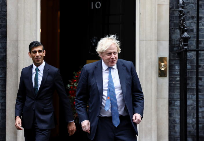 British Prime Minister Boris Johnson and Chancellor of the Exchequer Rishi Sunak walk out of Downing Street to meet Michelle Ovens of Small Business Saturday, in London, Britain, December 1, 2021. REUTERS/Henry Nicholls