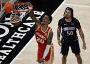 Atlanta Hawks' John Collins (20) scores as Orlando Magic guard Cole Anthony (50) watches during the second half of an NBA basketball game Tuesday, April 20, 2021, in Atlanta. (AP Photo/Ben Margot)