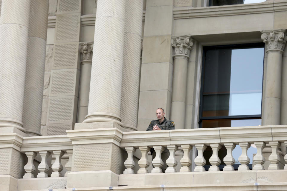 In this Wednesday, Jan. 6, 2021, photo, a Wyoming Highway Patrol officer watches a peaceful protest from the upper levels of the Capitol in downtown Cheyenne, Wyo. The protest was in response to the murder of George Floyd, as well as Breonna Taylor and many other people of color across the country, and was meant to show unity for change. Wyoming Gov. Mark Gordon quietly mobilized dozens of National Guard troops in case of any violence at the state Capitol in Cheyenne, Wyo., in January. The deployment came to light Friday, March 5, 2021, after an Associated Press inquiry after the Jan. 6 riot at the U.S. Capitol, which left five dead. (Michael Cummo/The Wyoming Tribune Eagle via AP)