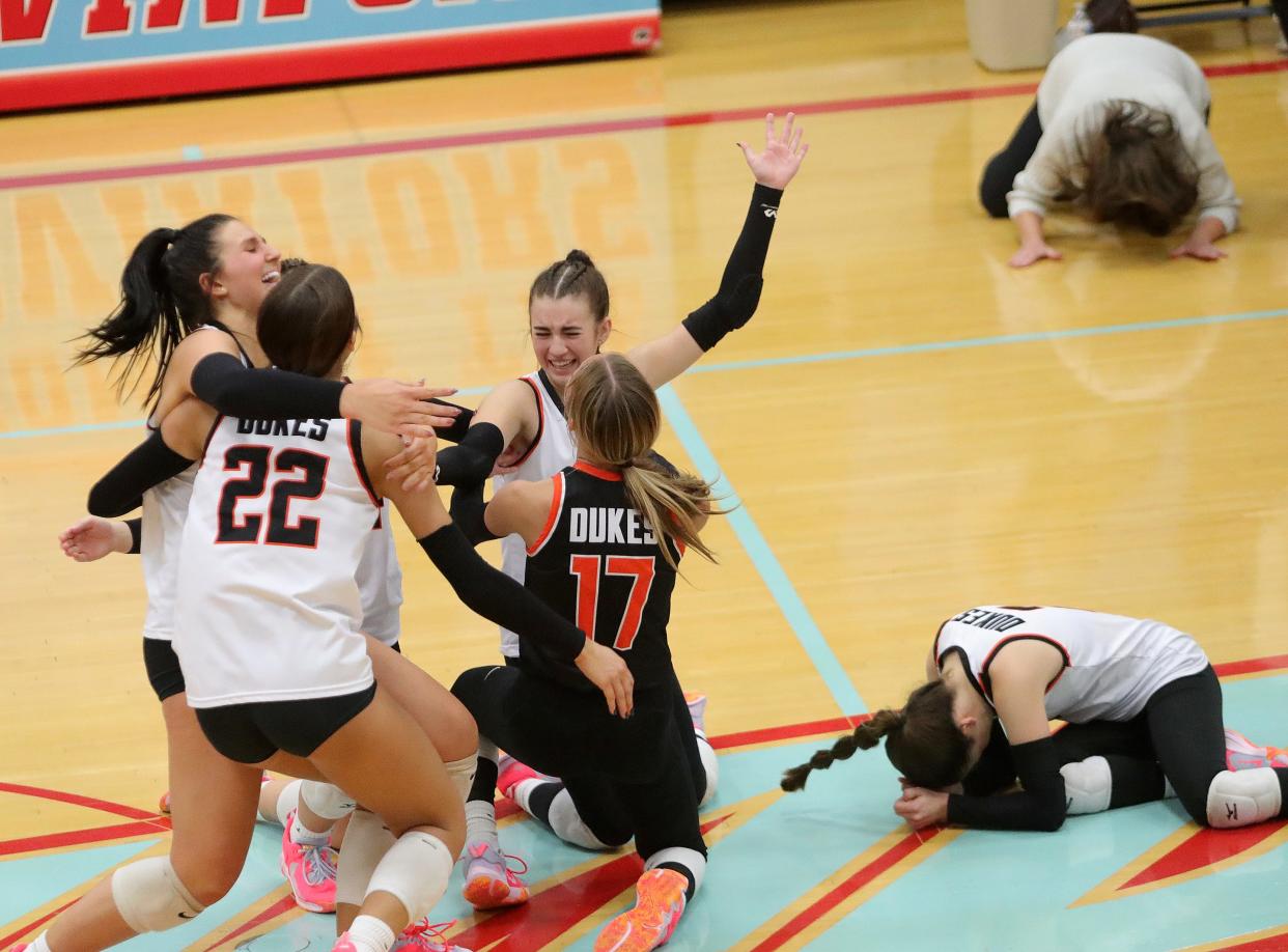 The Marlington volleyball team, including head coach Stephanie Tortola, top, right, celebrates after a five-set win over Kenston in a Division II regional semifinal, Thursday, Nov. 2, 2023, at Alliance High School.