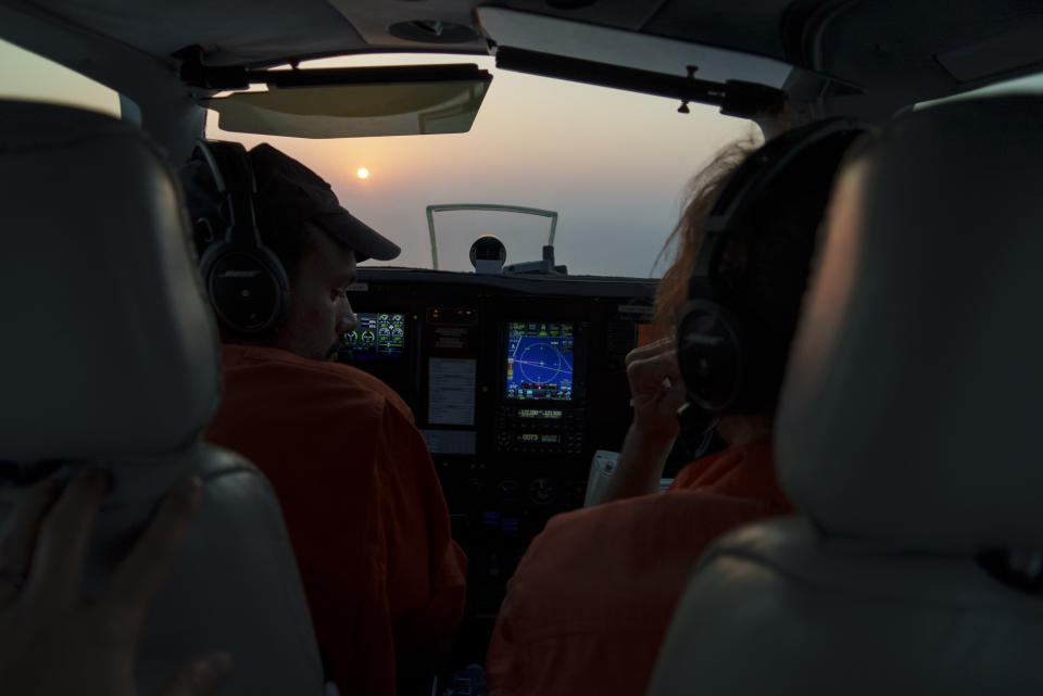 Volunteer French pilot Augustin Clot, left, and tactical coordinator Jakob Fruehmann, of Austria, talk inside the cockpit of the humanitarian monitoring aircraft Seabird, as they search for migrant boats in distress in the Mediterranean Sea between Libya and the Italian island of Lampedusa, Monday, Oct. 4, 2021. The plane, owned and operated by the German NGO Sea-Watch, seeks to monitor human rights violations at sea and assist in migrant rescues. (AP Photo/Renata Brito)